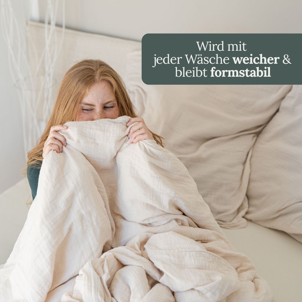 Frau zieht cremefarbene Musselin-Decke bis zur Nase – wird mit jeder Wäsche weicher