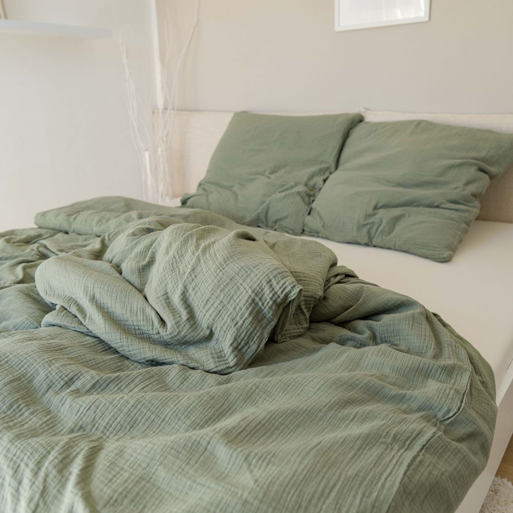 Cozy Set: olivgrüne Musselin-Bettwäsche aus Bio-Baumwolle mit Kopfkissen auf einem Bett