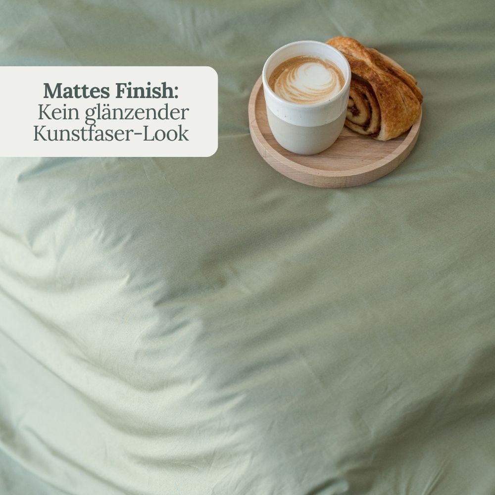 Kaffee und Croissant auf olivgrüner Perkal-Bettwäsche – mattes Finish ohne Glanz