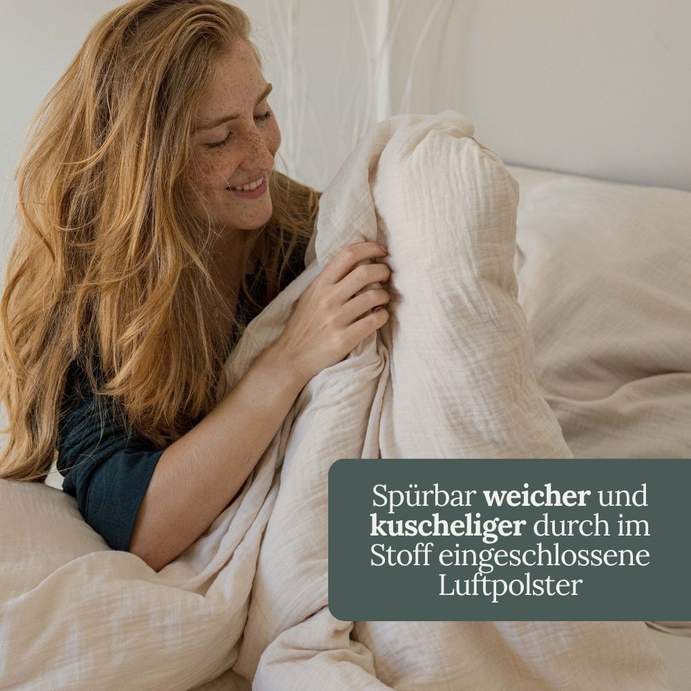 Lächelnde Frau mit cremefarbener Musselin-Decke – weich durch eingeschlossene Luftpolster