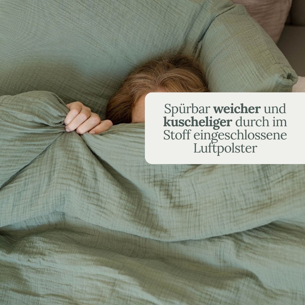 Person kuschelt sich unter olivgrüne Musselin-Bettwäsche – weich durch eingeschlossene Luftpolster